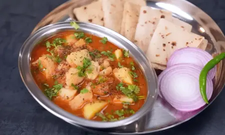 Plated Aloo Kali Mirch served with soft ghee-brushed phulkas