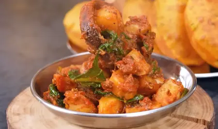 Plated dish of aloo palak sabzi served with kasoori methi poori