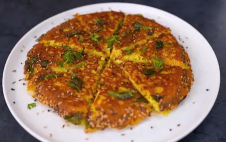 Sliced and served crispy Gujarati rava handvo with chutney