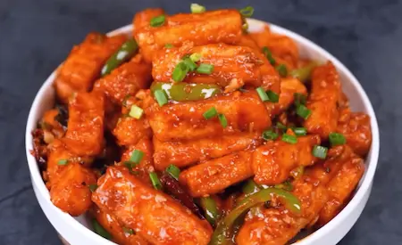 Restaurant-style paneer crispy tossed in red sauce, garnished with spring onions