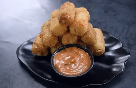 Frying jalapeño cheese poppers till golden brown and preparing dip