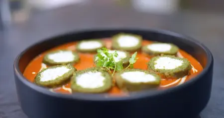 Serving palak paneer kofta sabzi with creamy gravy and naan