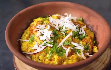 adding jeeravan masala to the creamy bhutte ka khees before serving