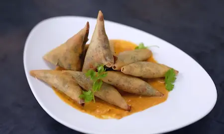 Plating Cheesy Corn Palak Samosa Recipe with tomato thecha for serving