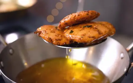 Frying maddur vade in hot oil until they become golden and crispy