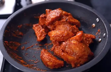 Cooking Goan Chilli Potato with onions, garlic, and recheado paste