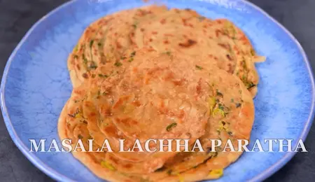 Layered methi paratha cooking on tawa with ghee