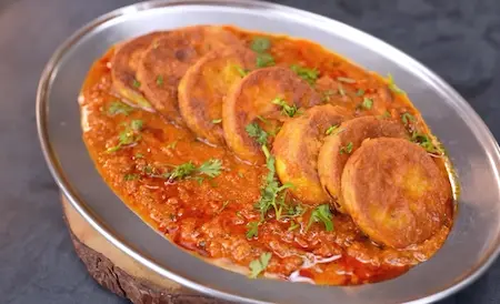 Chatpata Lauki Masala garnished with coriander, served with Indian bread on a plate.