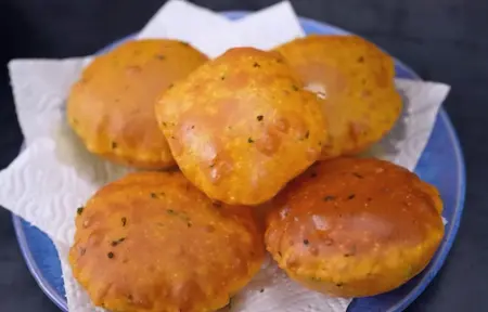 Crispy golden kasoori methi pooris being fried in oil
