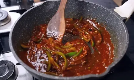 Green capsicum and spring onion whites stir-fried in spicy sauce for paneer