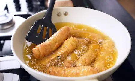 Deep frying sambar vadi until golden and crispy in medium hot oil