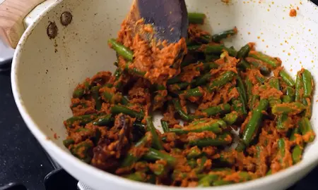 adding curd masala and french beans to curry for french beans curry recipe