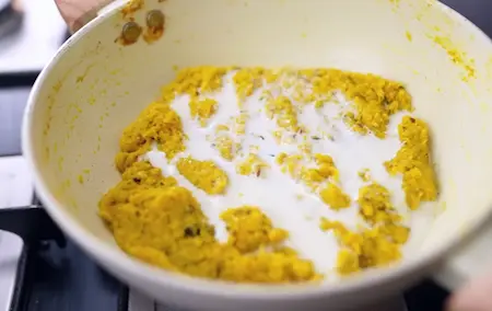 adding milk to the grated corn mixture to make bhutte ka khees creamy