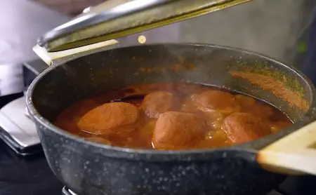 Simmering Punjabi Dum Aloo on low heat for full flavor