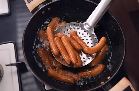 Step 4: Piping Fulwadi dough into hot oil and frying until golden and crispy