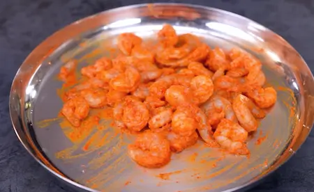 Marinating prawns with spices and lemon juice.