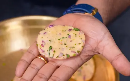 Shaping the dough into small balls and flattening them into patties for maddur vade recipe