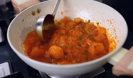 Sweet potato curry simmering with amchur and coriander - Shakarkand Curry final step
