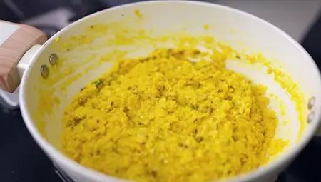 adding grated corn to the tempering mixture for bhutte ka khees