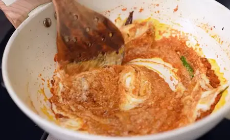 Tomato puree and curd added to sautéed masala mixture for a creamy Chatpata Lauki gravy.