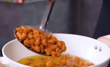 Peanuts frying in hot oil in a pan