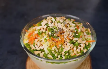 Seasoning Gujarati handvo batter with spices and crushed peanuts