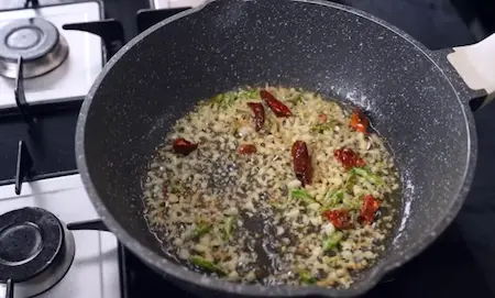 Ginger, garlic, dry red chilli and green chilli sizzling in wok for Indo-Chinese sauce