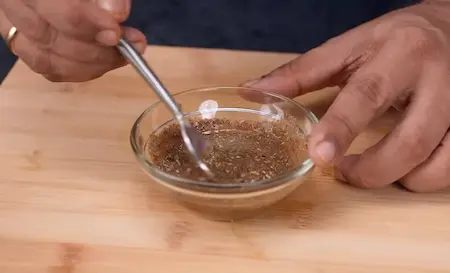 Mixing masala paste with garam masala, amchur, and water for sealing the sambar vadi rolls