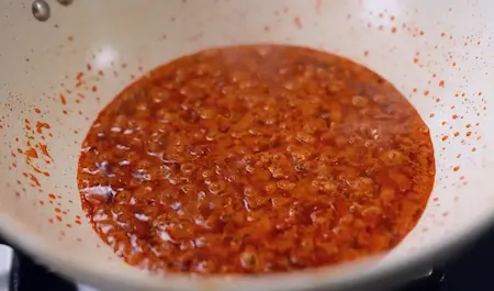 Cooking curry masala with tomato, curd and spices for Shakarkand Curry