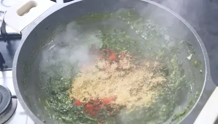 Step 6: adding spices and spring onions to Methi Palak Ka Kapa