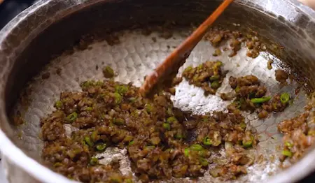 Golden brown onions with green chilli and ginger-garlic paste in pan for Methi Chaman base