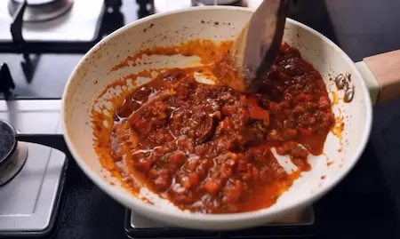 Cooking the curry base with tomatoes and spices for aloo palak