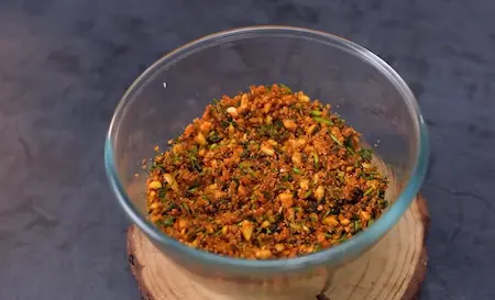 Cooking the stuffing with sesame, coconut, peanuts, and fresh coriander for sambar vadi