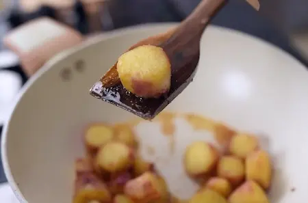 Frying sweet potatoes for crispy texture in shakarkand curry
