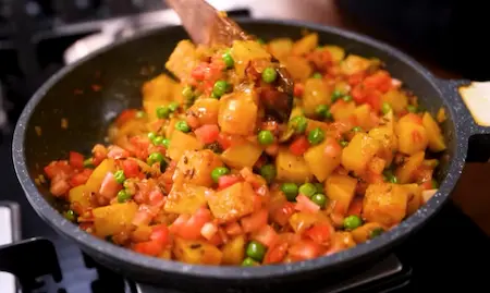 Step 8: adding peas and tomatoes for Aloo Matar ki Sukhi Sabzi