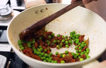 Step 6: tomatoes and green peas for Soya Kheema Samosa Recipe