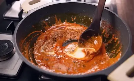 Step 5: Adding curd and tomato-onion gravy paste to the masala for Paneer Changezi