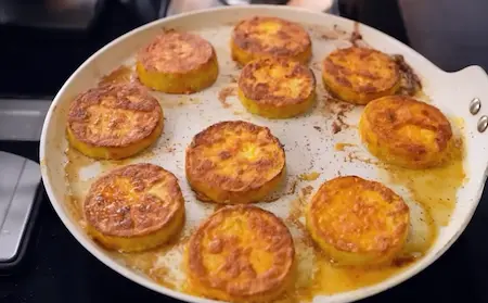 Coated lauki slices being shallow fried to a golden crisp for Chatpata Lauki Masala.