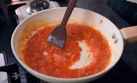 Sautéed onions and fresh tomato puree cooked to make masala base for Aloo Kali Mirch