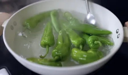 Blanching bhavnagri chillies in vinegar water for jalapeño cheese poppers