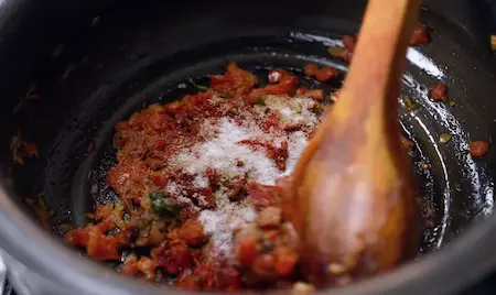 Cooking shallots, green chillies, ginger-garlic, and tomatoes until soft for Salna gravy