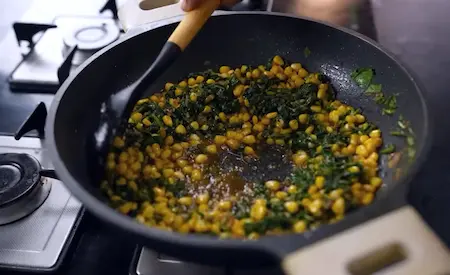Cooking corn and spinach mixture with spices for Cheesy Corn Palak Samosa Recipe