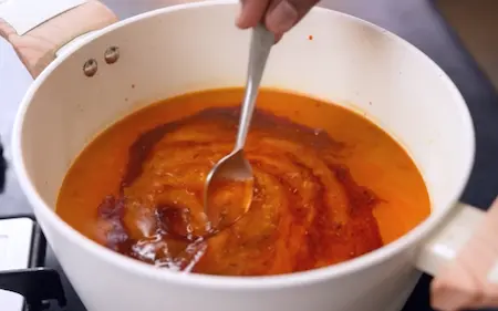 Pressure cooked mixed dal being tempered with ghee, cumin seeds, hing and red chili powder