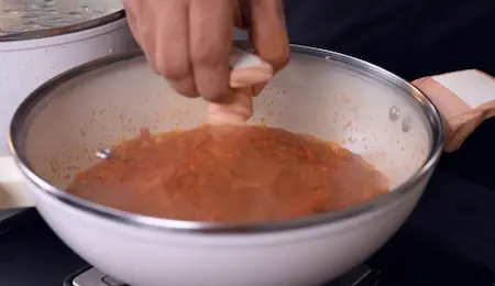 Cooking the tomatoes into the biryani masala.