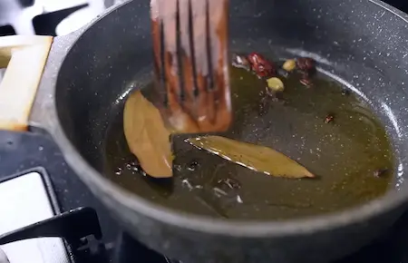 Tempering whole spices in mustard oil for Punjabi Dum Aloo