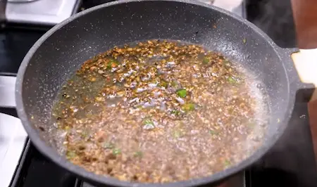Step 4: adding pounded masala to Aloo Matar ki Sukhi Sabzi